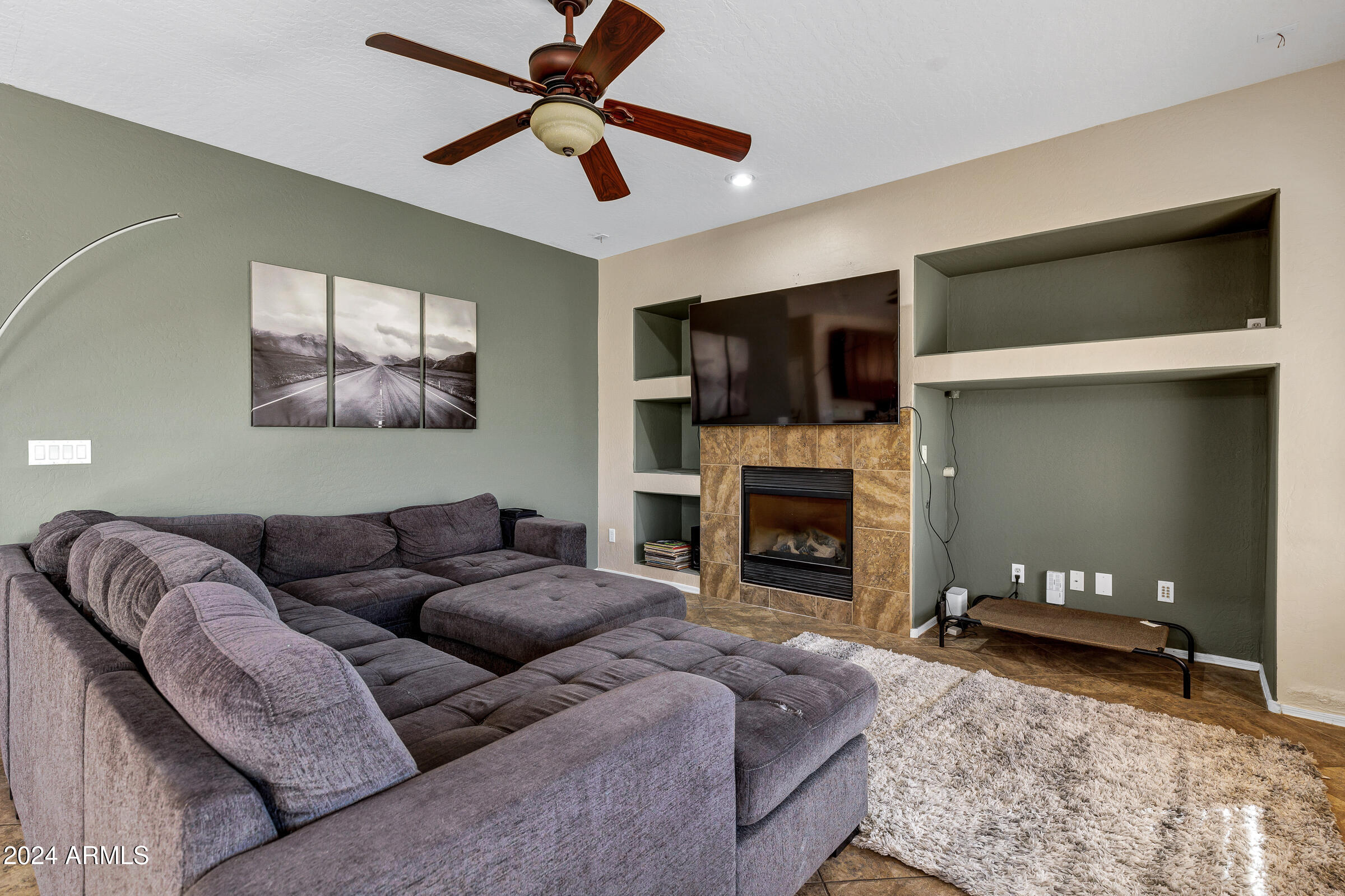 2801 West Silver Fox Way Phoenix, AZ 85045 - Photo 19 of 76 a living room with furniture a fireplace and a flat screen tv