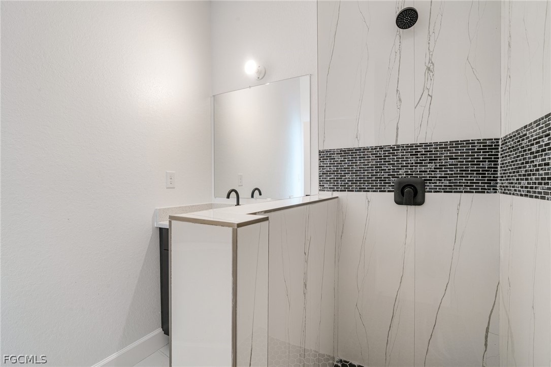 4725-4727 27th Street Southwest, Unit 4725 Lehigh Acres, FL 33973 - Photo 18 of 22 a bathroom with a sink and a mirror