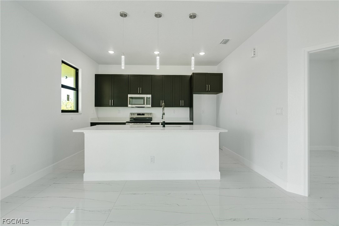 4725-4727 27th Street Southwest, Unit 4725 Lehigh Acres, FL 33973 - Photo 2 of 22 a living room with stainless steel appliances a couch and a flat screen tv