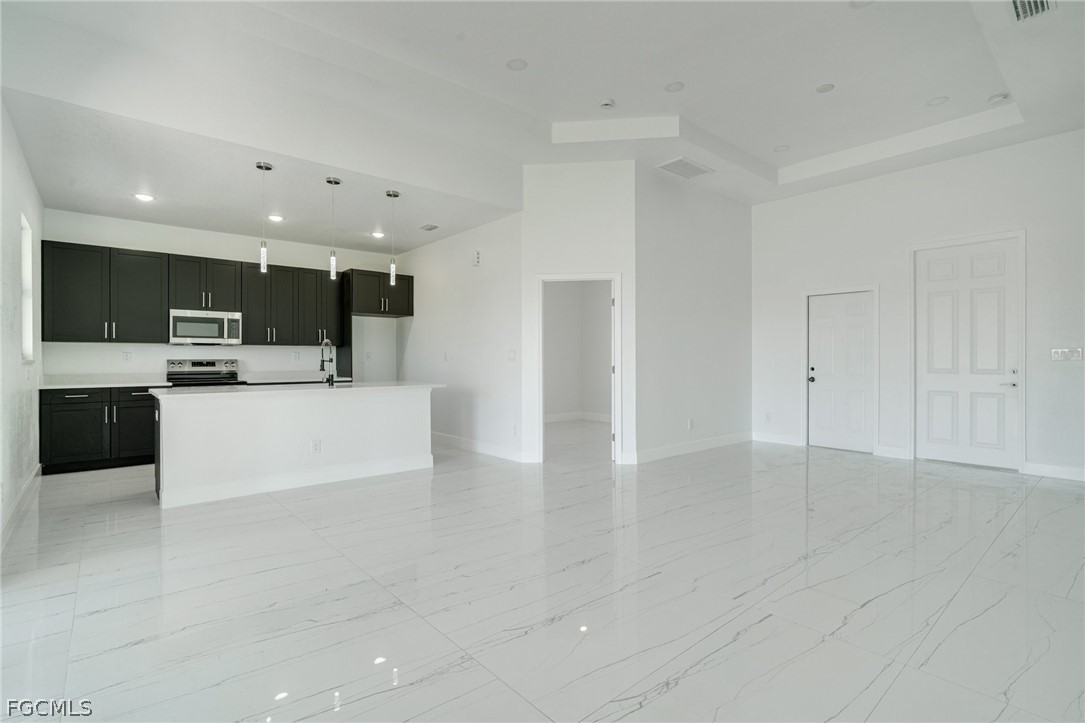 4725-4727 27th Street Southwest, Unit 4725 Lehigh Acres, FL 33973 - Photo 3 of 22 a view of kitchen with stainless steel appliances a refrigerator and a stove top oven