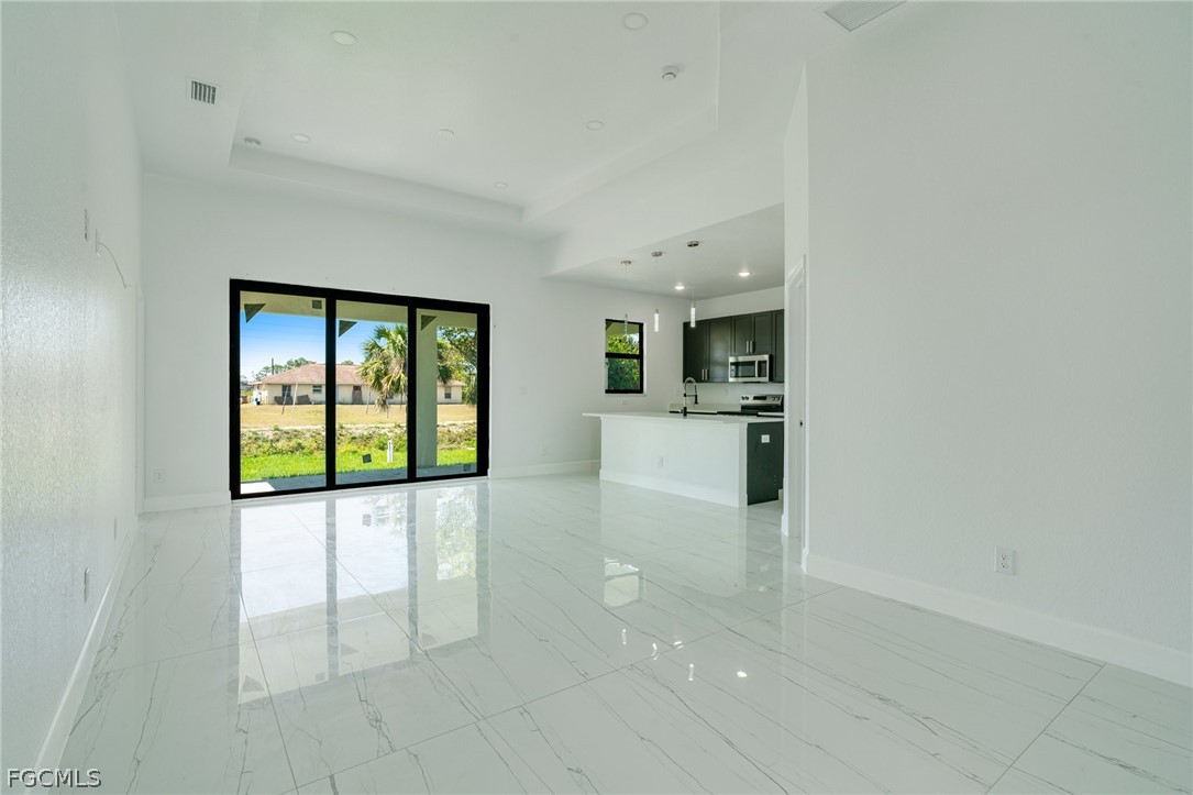 4725-4727 27th Street Southwest, Unit 4725 Lehigh Acres, FL 33973 - Photo 6 of 22 a view of a kitchen with a sink and dishwasher a stove top oven with white cabinets