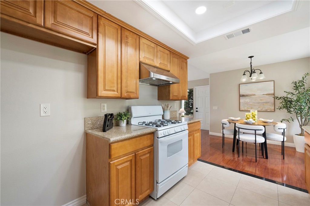 242 Mountain Court Brea, CA 92821 - Photo 18 of 54 a kitchen with a sink a stove cabinets dining table and chairs