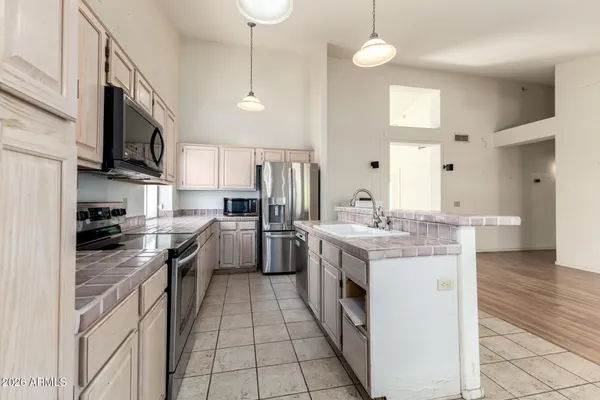 a kitchen with stainless steel appliances granite countertop a stove a sink and a refrigerator