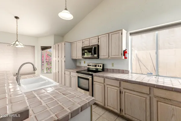 a kitchen with granite countertop a stove a sink and a microwave