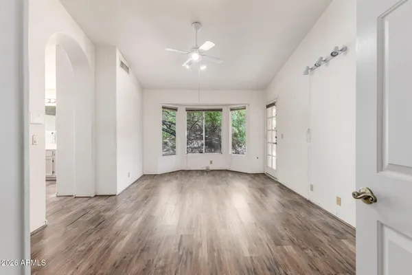 an empty room with wooden floor and windows