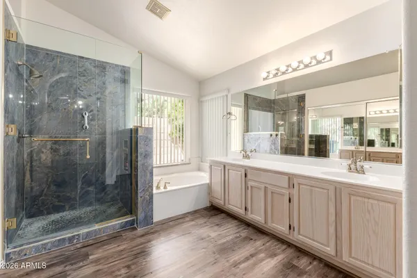 a bathroom with a bathtub a sink and a large mirror
