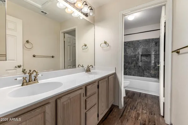 a bathroom with a double vanity sink mirror and shower