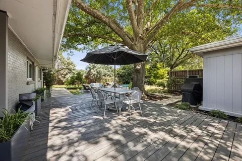 a view of a patio with a table and chairs under an umbrella