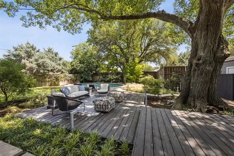 a view of deck with furniture and trees