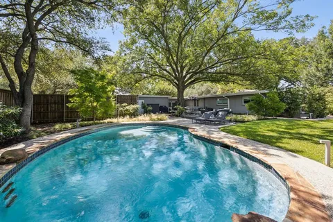 a swimming pool with outdoor seating and yard