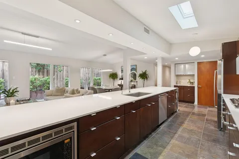 a large kitchen with kitchen island a sink stainless steel appliances and cabinets