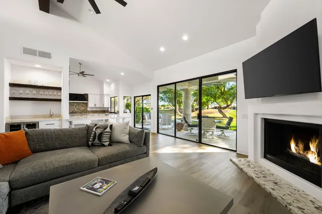 a living room with furniture a flat screen tv and a fireplace