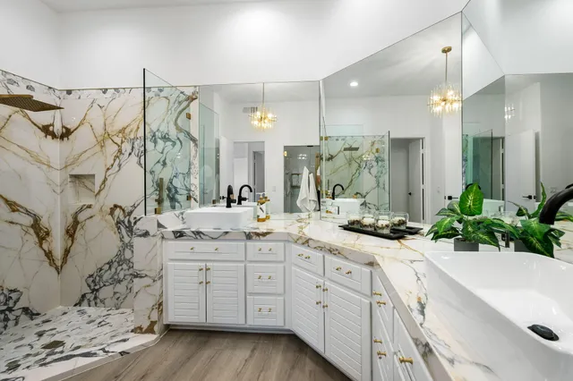 a spacious bathroom with a granite countertop sink mirror and a shower