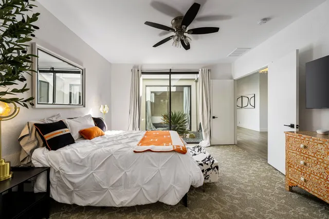 a bedroom with a bed and dresser with mirror