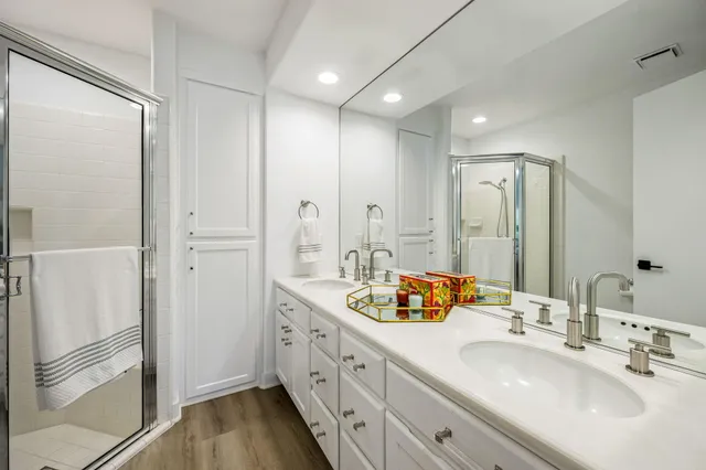 a spacious bathroom with double vanity and mirrors