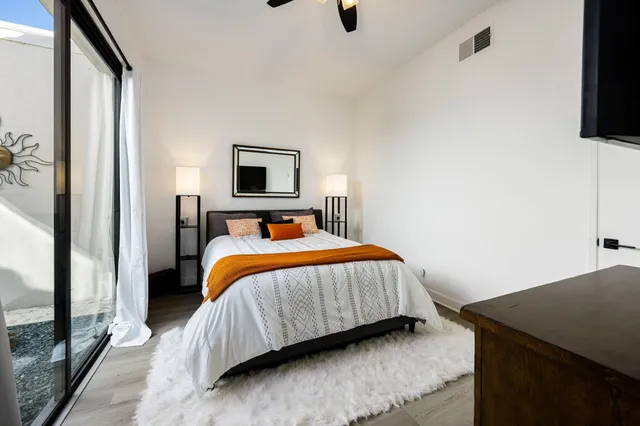 a bedroom with a bed and a flat tv screen on a dresser