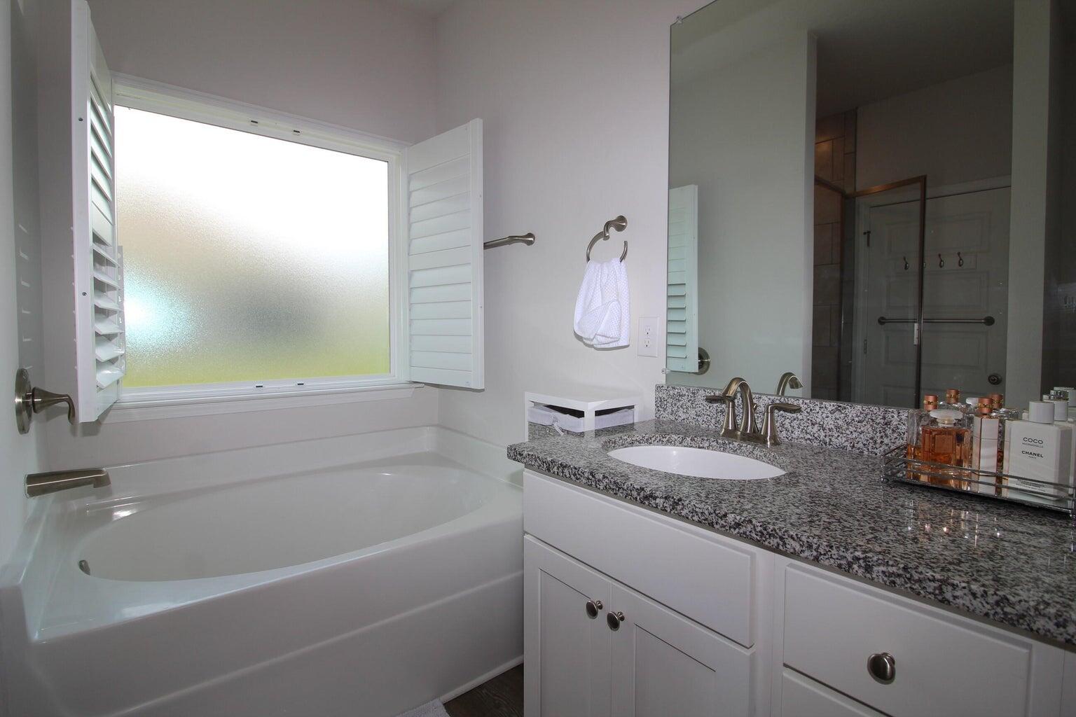 454 Lightning Bug Lane Freeport, FL 32439 - Photo 20 of 41 a bathroom with a granite countertop sink mirror and a bathtub