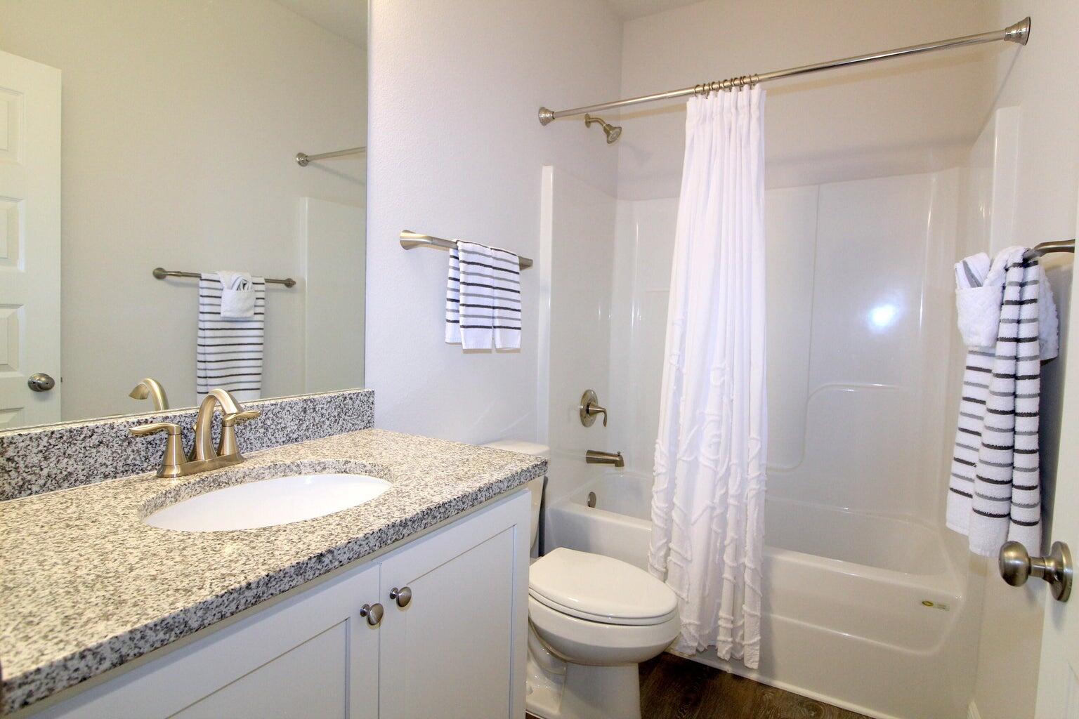 454 Lightning Bug Lane Freeport, FL 32439 - Photo 24 of 41 a bathroom with a granite countertop sink toilet and shower