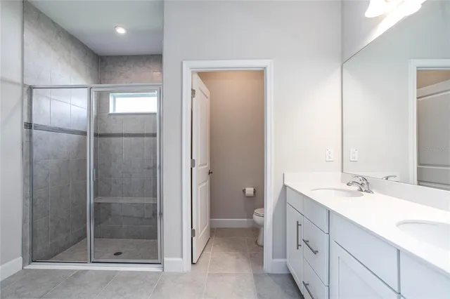 a bathroom with a double vanity sink mirror and shower