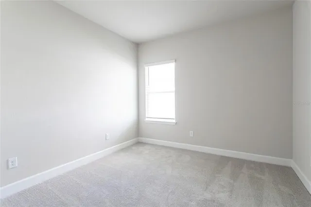 an empty room with wooden floor and window