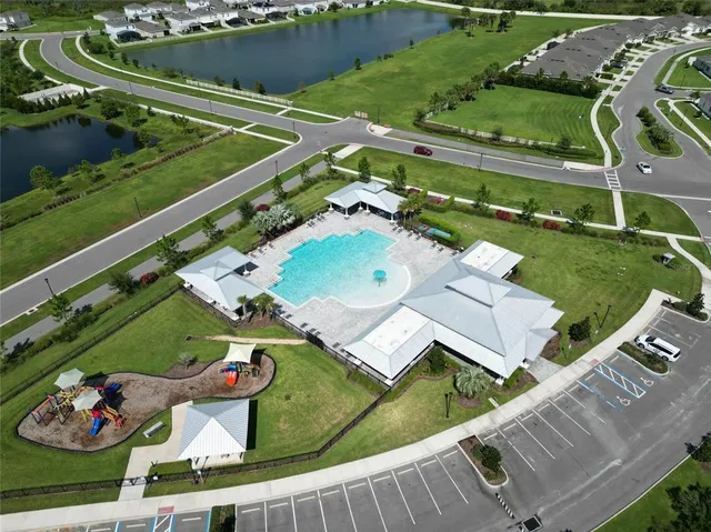 an aerial view of residential houses with outdoor space and parking