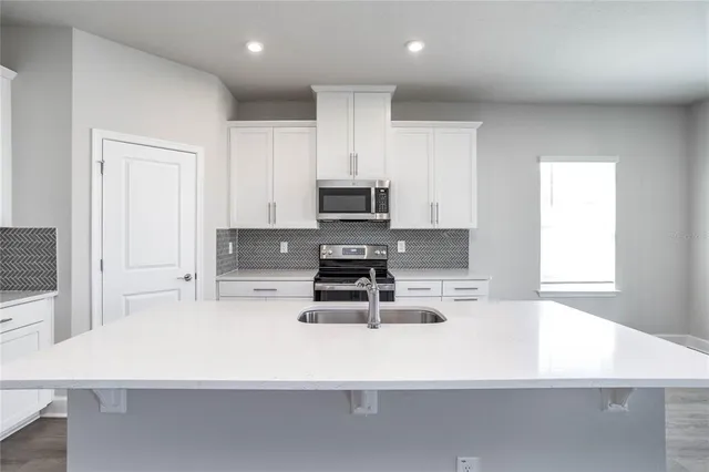 a white kitchen with stove top oven and cabinets
