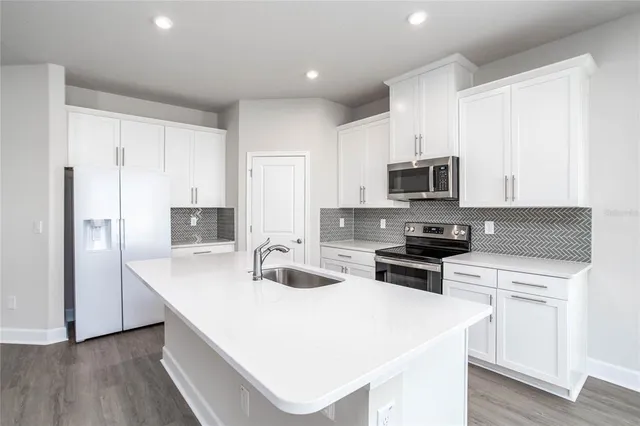 a kitchen with white cabinets and stainless steel appliances