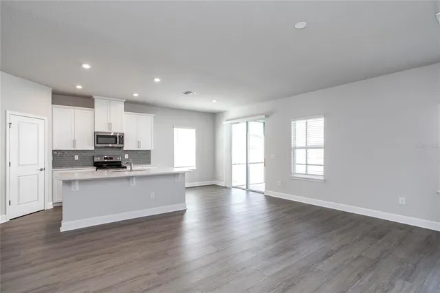 a kitchen with stainless steel appliances granite countertop a stove a sink and a refrigerator