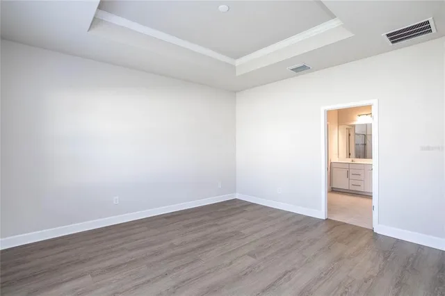 a view of an empty room with wooden floor