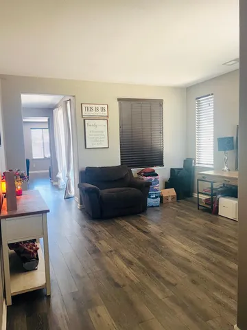 a living room with furniture and a wooden floor