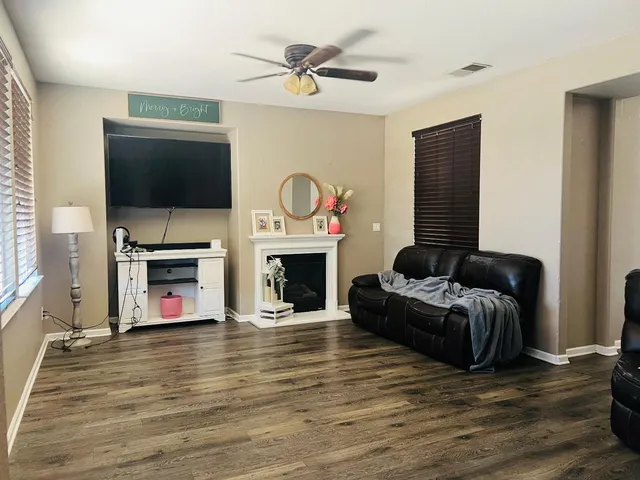 a living room with furniture a flat screen tv and a fireplace