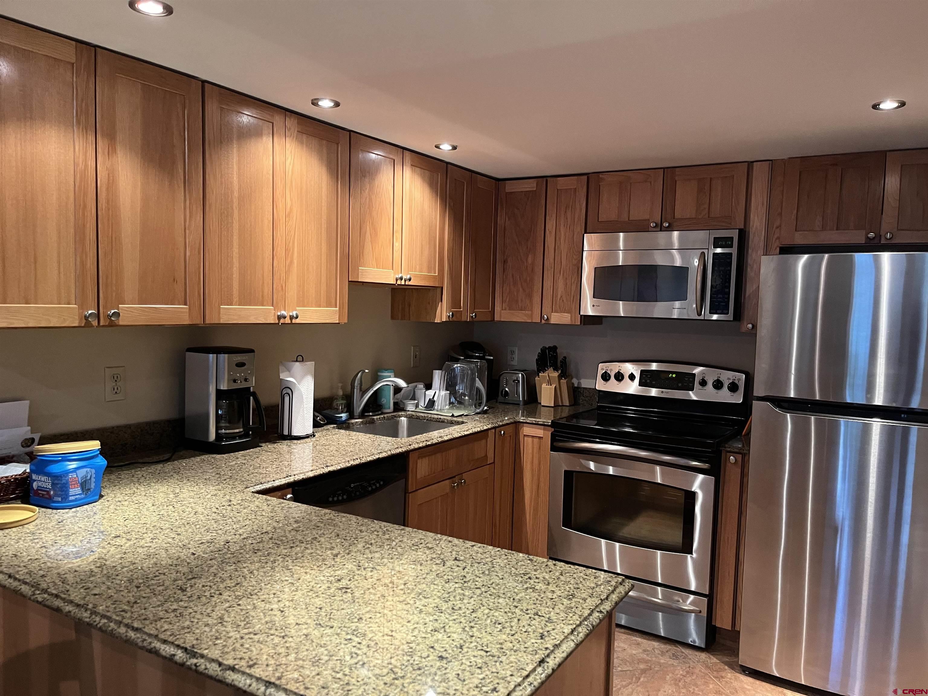 6 Ferringway Circle, Unit 22 Durango, CO 81301 - Photo 7 of 15 a kitchen with stainless steel appliances granite countertop a stove a sink and a microwave
