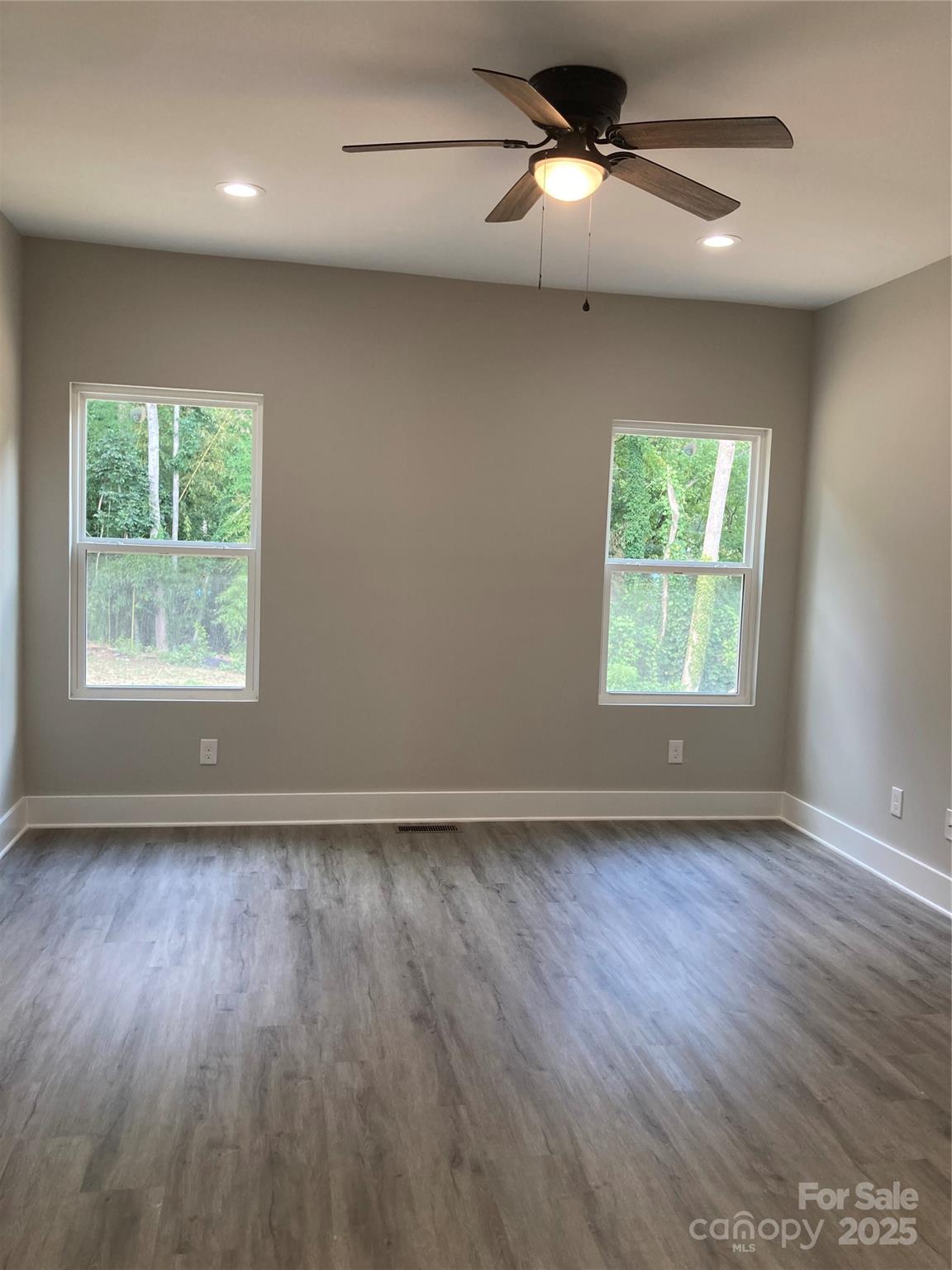 318 Davis Park Road Gastonia, NC 28052 - Photo 15 of 24 an empty room with wooden floor chandelier fan and windows