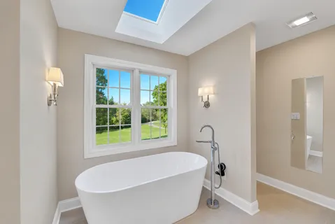 a bathroom with a bathtub and a window