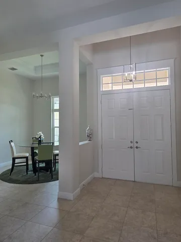a bedroom with two beds and a chandelier