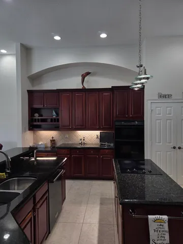 a kitchen with a sink and a stove top oven with wooden floor