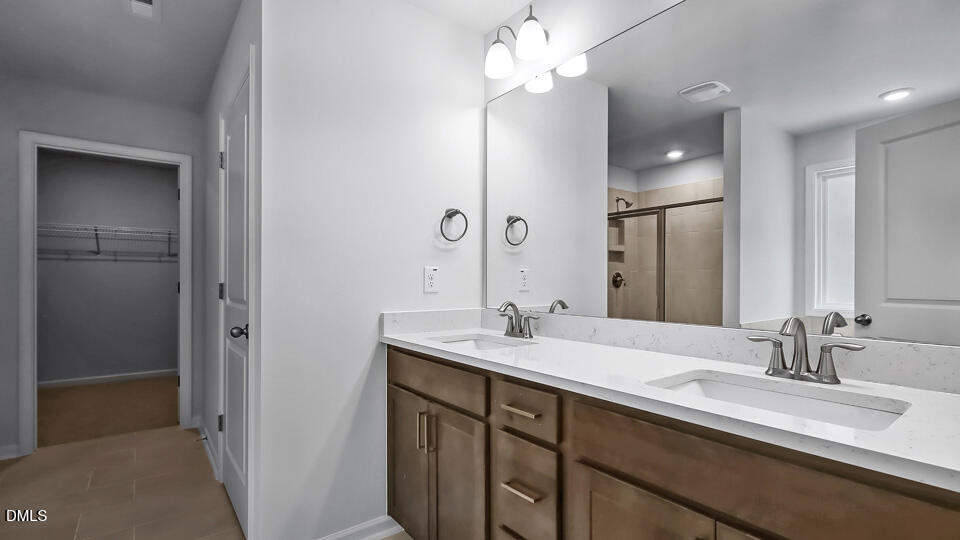 7589 Percussion Drive Apex, NC 27539 - Photo 26 of 33 a bathroom with a double vanity sink and a mirror