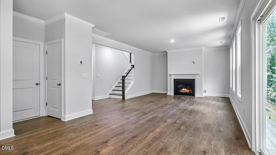 7589 Percussion Drive Apex, NC 27539 - Photo 7 of 33 a view of an empty room with wooden floor and a window