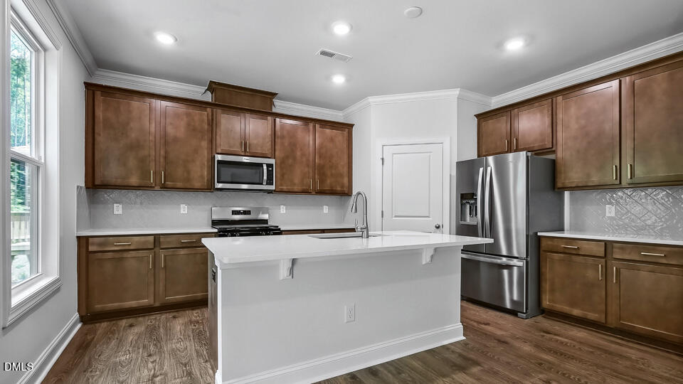 7589 Percussion Drive Apex, NC 27539 - Photo 9 of 33 a kitchen with stainless steel appliances granite countertop a refrigerator stove microwave and sink