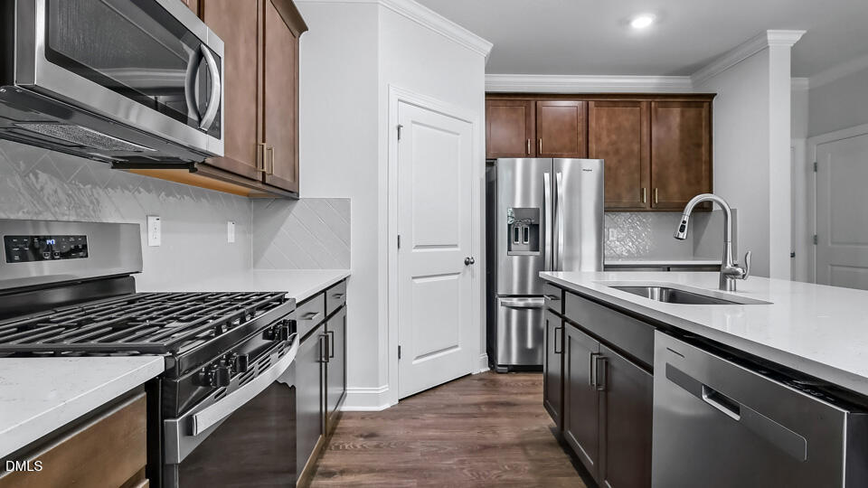 7589 Percussion Drive Apex, NC 27539 - Photo 10 of 33 a kitchen with stainless steel appliances granite countertop a sink stove and refrigerator