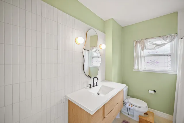 a bathroom with a toilet a sink and mirror