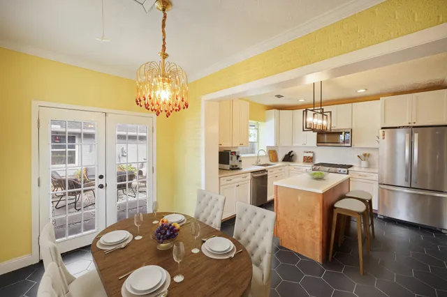 a kitchen that has white cabinets and stainless steel appliances