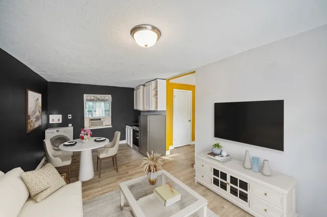 a kitchen with stainless steel appliances granite countertop a stove a sink dishwasher a refrigerator white cabinets and wooden floor