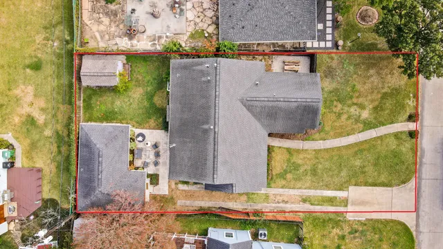 aerial view of a house with a yard and a large tree