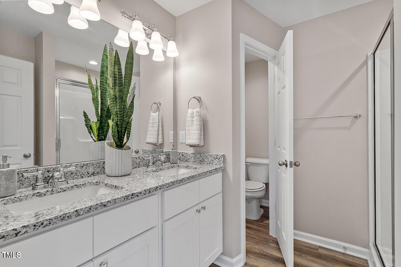 878 John Street Clayton, NC 27520 - Photo 10 of 23 a bathroom with a granite countertop sink and a mirror