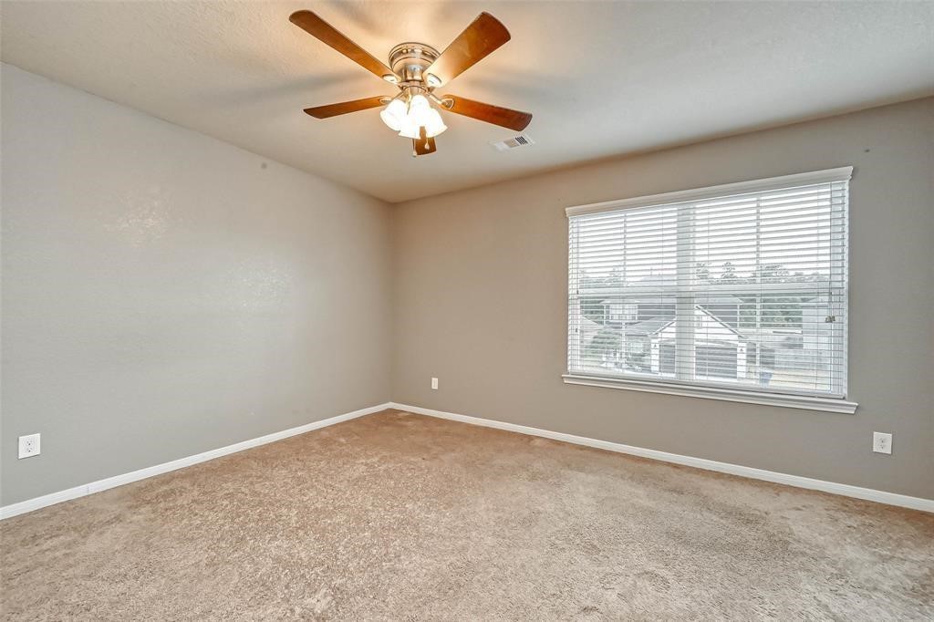 2561 Magnolia Fair Way Spring, TX 77386 - Photo 16 of 35 an empty room with a chandelier fan and windows