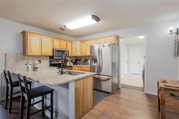 a kitchen with refrigerator a table chairs and a refrigerator