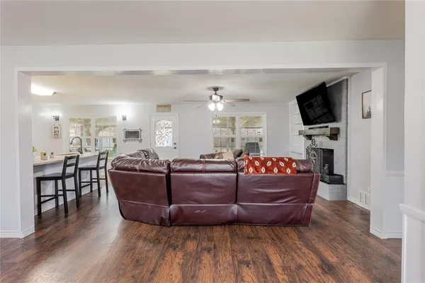 a living room with furniture a flat screen tv and kitchen view