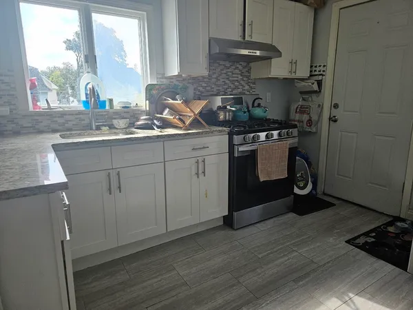 a kitchen with a sink cabinets and a window