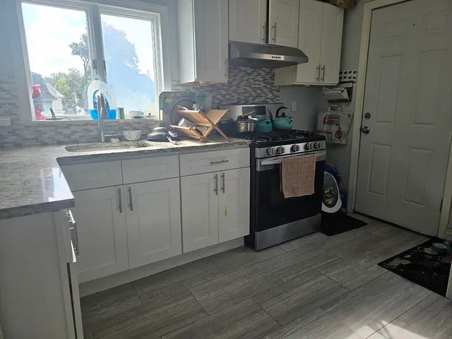 a kitchen with a sink cabinets and a window